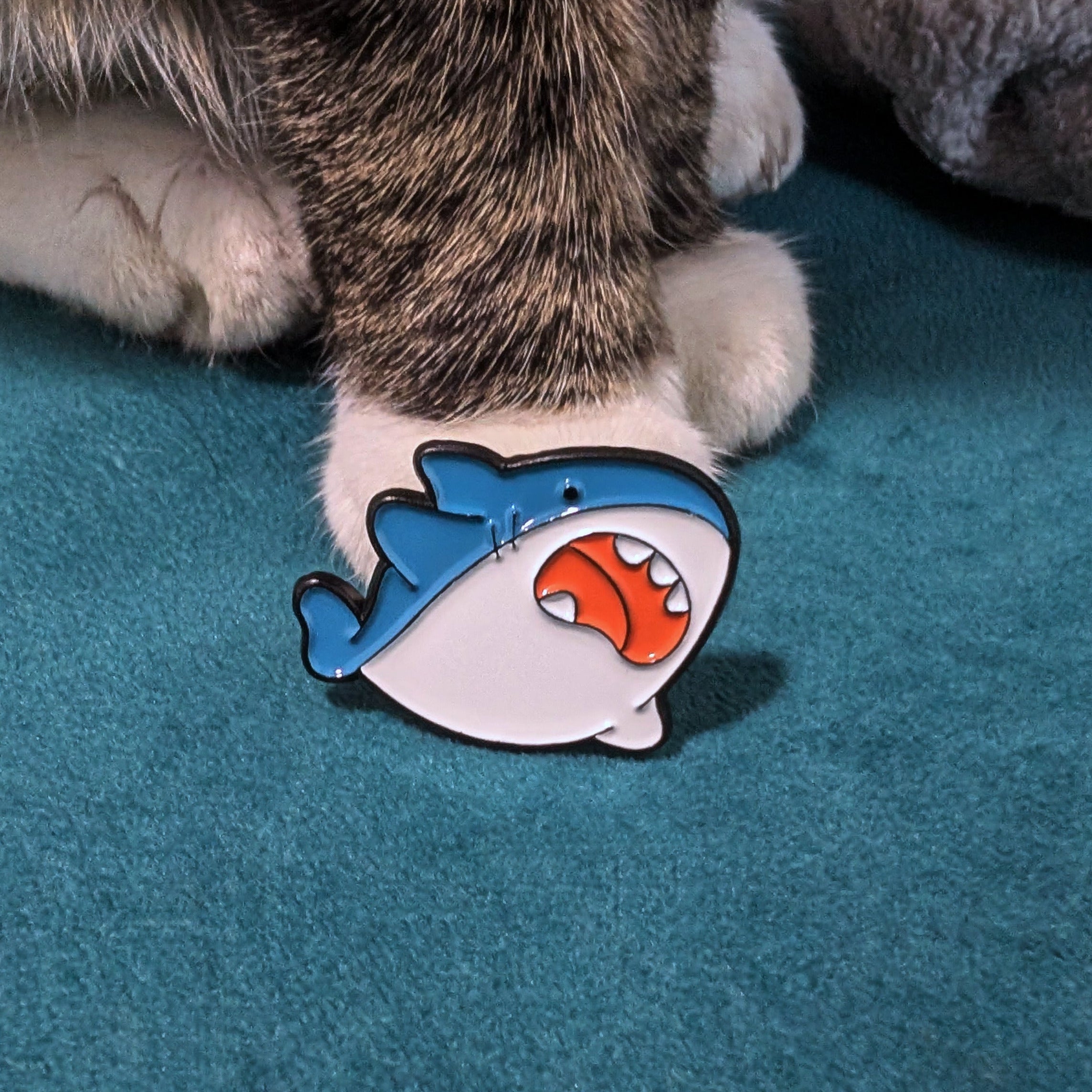 Round, chubby cartoon shark enamel pin